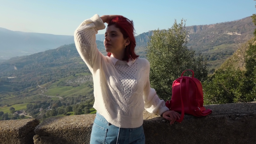 Beautiful girl sitting on the balcony in the mountains