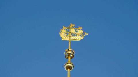 sailing ship weather vane on the spire of the Admiralty high in the blue sky, symbol of St. Petersburg is rotated from the wind, low angle