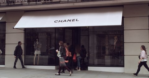 LONDON - CIRCA 2015: Shot of luxury goods boutique Chanel store front in Central London as shoppers pass by in the foreground.