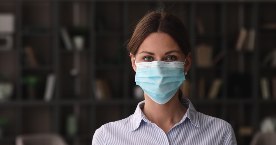 Caucasian happy 35s woman looking at camera, taking off protective disposable facemask, feeling relieved breathing fresh air indoors, personal safety quarantine covd19 measures, pandemic outbreak. Royalty-Free Stock Footage #1068565541