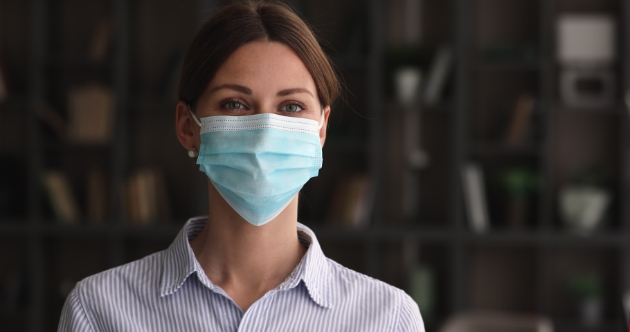 Head shot smiling beautiful young woman taking off protective facial medical mask, deeply breathing fresh air, feeling excited of defeating coronavirus infectious or living without respirator. Royalty-Free Stock Footage #1068565562