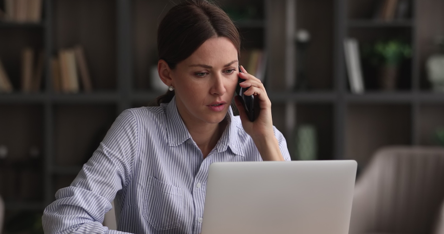 Stressed unhappy young woman holding unpleasant telephone conversation, working on computer in office, complaining about bad service work or feeling frustrated of professional business failure. Royalty-Free Stock Footage #1068565892