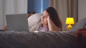 Obese woman lying on bed working online from home with laptop. Overweight young female relaxing in bedroom surfing internet or shopping online on computer - Powered by Shutterstock - Get 15% off with code: PIKWIZARD15