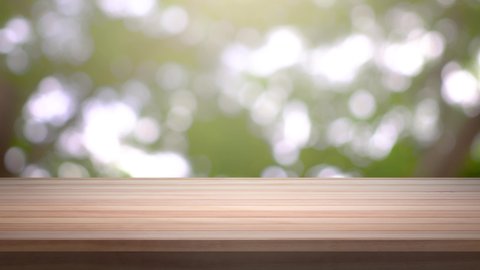Close up Top Wood table bar and nature tree bokeh blurred background. At morning time and beautiful nature sun light, Top wood table space area for products shows. 4096x2304. 4K UHD. Video Clip