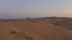 Sunrise over the sand dunes in the desert, Aerial view. Sand dunes in the Gobi Desert. 4k ungraded video.