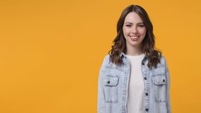 Surprised excited young woman 20s in denim jacket white t-shirt isolated on yellow background studio. People lifestyle concept. Pointing index finger aside up say wow showing thumbs up like gesture - Powered by Shutterstock - Get 15% off with code: PIKWIZARD15