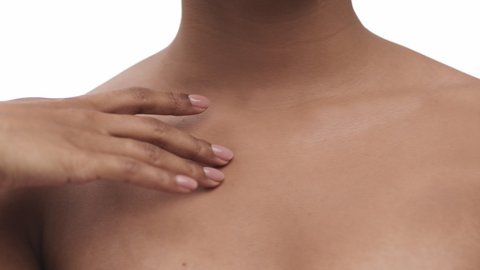 Perfect body condition. Close up shot of unrecognizable black lady stroking her neckline with smooth skin, tracking shot, slow motion