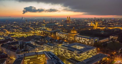 Stunning Munich Cityscape at Night with glowing City Streets and Office Building, Magical Day to Night Aerial Hyper Lapse moving Time Lapse above Big Metropolitan Area