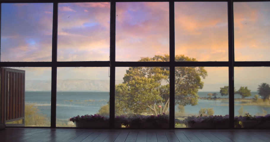 Adult man in suit walking near a big window at sunset, waiting for someone, looking at the lake. Slow motion, long shot.
 | Shutterstock HD Video #1068591260