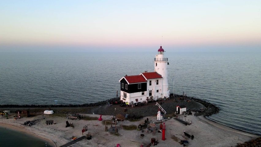 Paard van Marken, lighthouse at sun set along the water in the Netherlands, near Amsterdam in Marken. Aerial drone view.