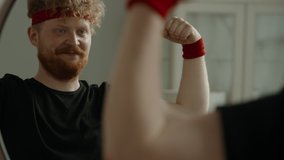 SLOW ZOOM IN Portrait of funny Caucasian man dancing and kissing his biceps in the mirror after working out. Motivation, self confidence concept - Powered by Shutterstock - Get 15% off with code: PIKWIZARD15