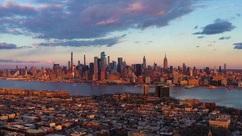 Urban Skyline of Midtown Manhattan, Jersey City and Hudson River at Sunset. Sunlight on Buildings. New York City, USA. Aerial View. Drone Flies Sideways