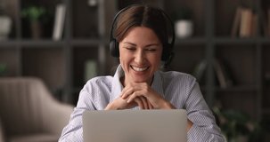 Young happy 35s businesswoman in headphones holding video call negotiations meeting with colleagues. Skilled female teacher giving educational lecture online using videoconference laptop.