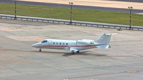 Generic Unmarked Business Executive VIP Jet Airplane on Platform Taxiing to International Airport Hangar on a Sunny Day