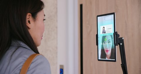 facial recognition concept - Asian businesswoman using face scanner to clock in work and unlock office door