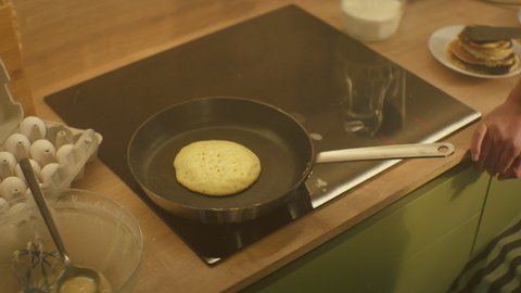 Frying Pan On The Stove. Pancake Burned On The Pan. Mans Hand Turns The Pancake To The Other Side. He Lingers When He Sees That The Pancake Has Burned.