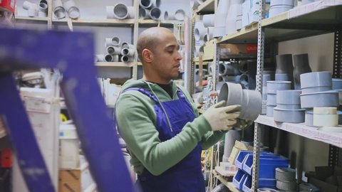 Latin american man choosing plastic pipes for plumbing work at building materials store . High quality FullHD footage