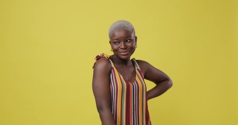 Happy woman posing over yellow background