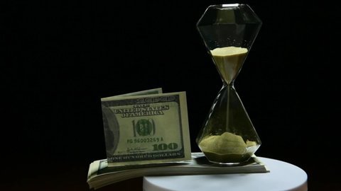 footage of sand clock money dark background 