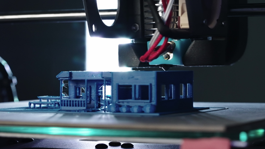 Close up of 3d Printer printing blue house slider shot in 4k