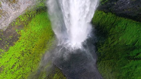 Aerial tilt up shot of beautiful waterfall from cliff in forest, drone flying over cascade - Salt Creek Falls, Oregon