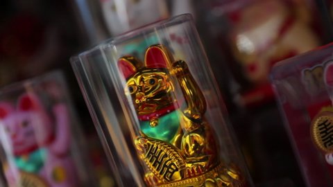 Close-up of golden Maneki Neko souvenir in glass jar at store - San Francisco, California