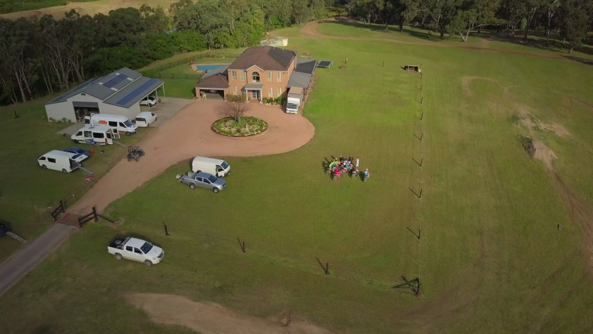 Aerial Descend Tilt Up: Riders With Bikes At Ranch Against Sky
