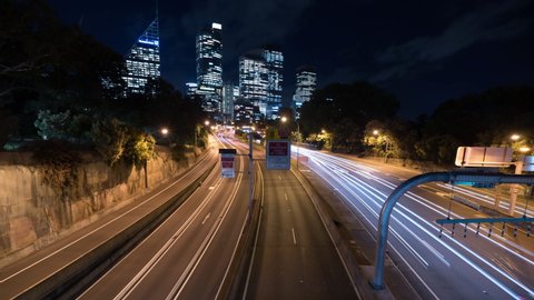 Time Lapse Lockdown: Light Trails On Highway Against Skyscrapers