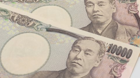 There are many Japanese 10,000 yen bills. They are slowly turning on the turntable.