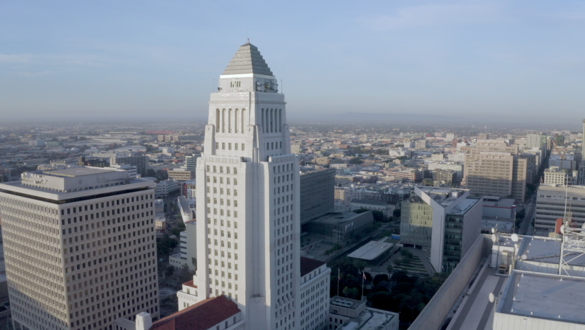 High Elevation Aerial Back: Los Angeles City Hall In Morning Light In Between Large Buildings In Downtown Royalty-Free Stock Footage #1068652580