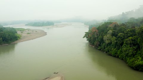 Aerial Pan: Vast River Stretches Endlessly Into Distance Obscured By Fog With Dense Jungle Banks