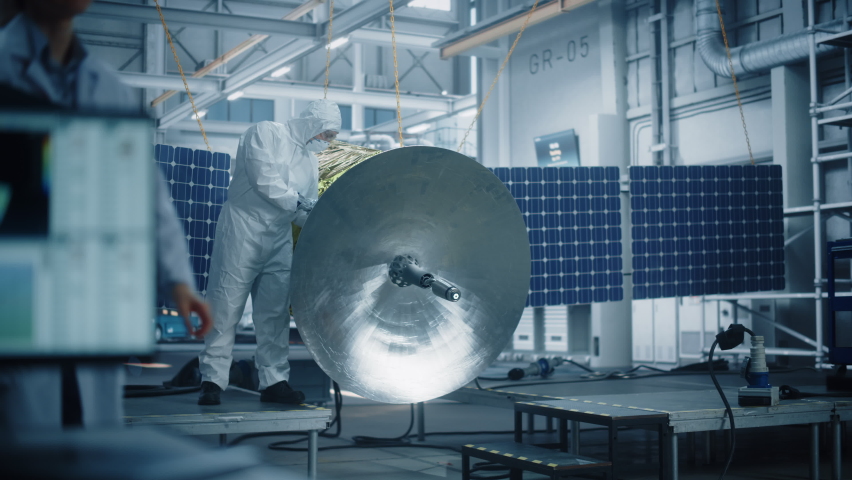 Engineer in Protective Suit Working on Satellite Construction. Aerospace Agency Manufacturing Facility: Scientists Developing Spacecraft for Space Exploration, Communications, Cosmos Observation Royalty-Free Stock Footage #1068654083