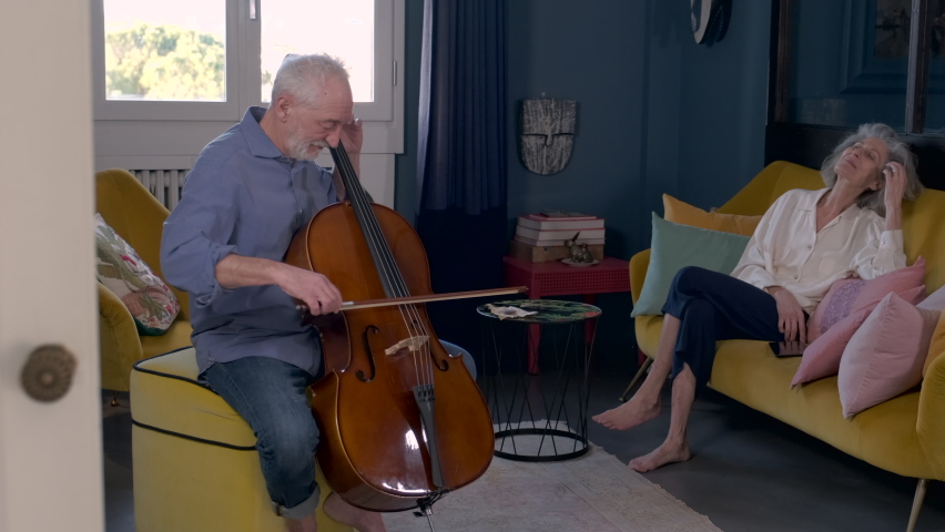 Senior woman listening to her husband playing the cello