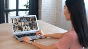 An Asian woman and diverse team on the laptop screen are talking and discussion via video connection, have online meeting, remote conference. Remote work concept