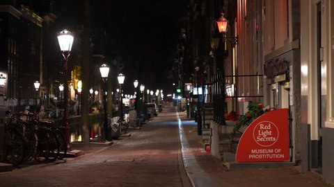 AMSTERDAM, NETHERLANDS – 5 MARCH 2021: Empty street in the Red Light nightlife district in central Amsterdam. Coronavirus Covid-19 evening curfew and lockdown measures in the Netherlands.