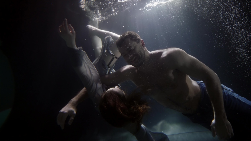 Male and female bodies underwater, beautiful woman is swimming around sexy man, slow motion shot | Shutterstock HD Video #1068670280
