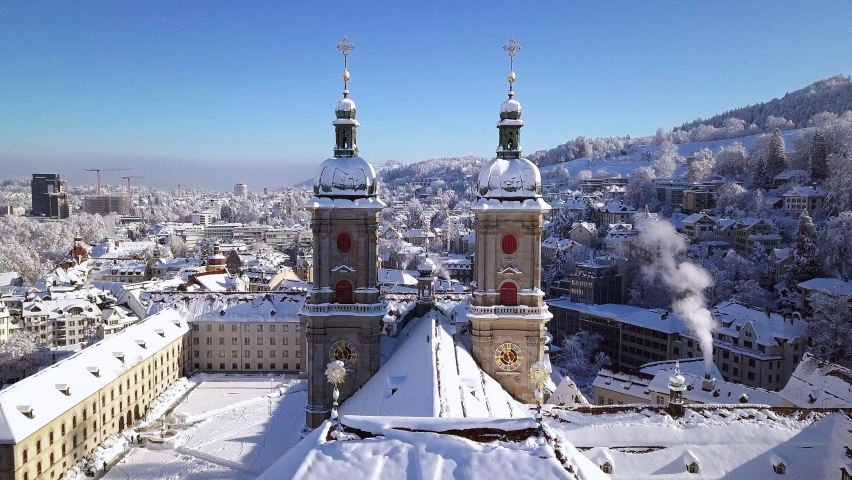 Winter view of the cathedral and old town covered with snow, Sankt Gallen, St. Gall, Switzerland. Aerial down top video clip shot by drone