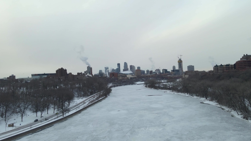 Mississippi River completely frozen close to downtown minneapolis during a cloudy cold winter afternoon during a polar vortex