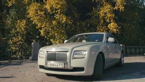 Saint-Petersburg, Russia - October, 2020: A white luxury Rolls-Royce stops in a picturesque autumnal location on the street.