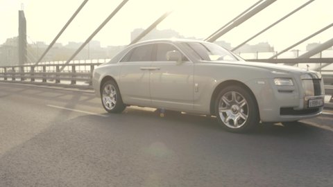 Saint-Petersburg, Russia - October, 2020: A prestigious white Rolls-Royce car is driving around the city. The camera shoots in movement below.