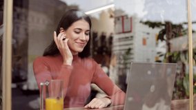 Smiling businesswoman using laptop and wireless handsfree for online meeting, video call, video conference. Communication online with colleagues,relatives,friends. Online education,remote working.