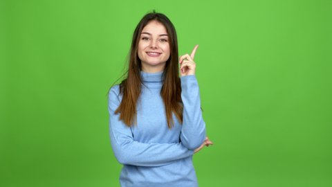 Young caucasian woman standing and thinking an idea pointing the finger up over isolated background. Green screen chroma key