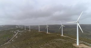 Aerial video with drone towards the back of the wind farm in cloudy winter day in Spain. Wind energy is one of the cleanest and renewable since it does not produce polluting emissions.