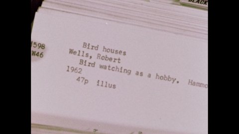 1960s: Finger points to card in card catalog. Card reads "BIRD WATCHING AS A HOBBY."