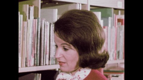 1960s: Library. Woman speaks and points to books. Sun's corona. Stars. Earth. Planets.