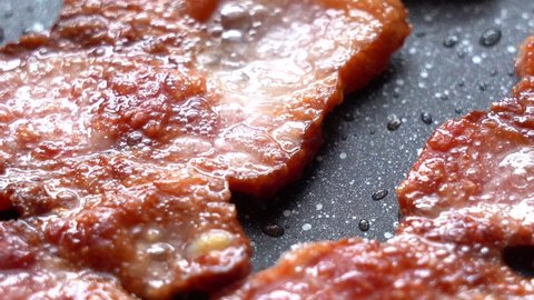 Fry the Bacon Pieces in a Pan. Crispy Pieces of Delicious Bacon are Fried in a Hot Skillet. Strips of Bacon, Fried in a Pan.