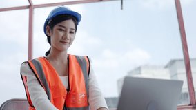 Workers or Asian businesswoman wearing hard hat sit in video conference using laptop. Remote operation Meeting With construction team. Currently working on site. Job interview. Advice service