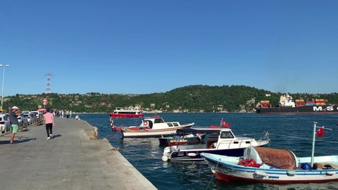 ISTANBUL - CIRCA JULY, 2019: Footage of moored fishing boats, cruise tour boat and dry cargo boat passing on Bosphorus strait in Arnavutkoy area of Istanbul. Asian side is in the view. Beautiful scene
