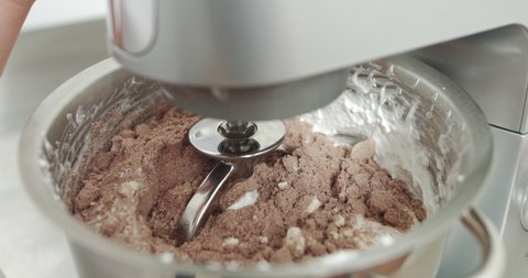 Mixing Brown Dough Cream In Mixing Machine. Manufacturing Process Of Sweet Cake Or Macarons Cookies. Using Modern Electric Food Processor To Mixing The Dough For Baking A Cake Or Cookies.