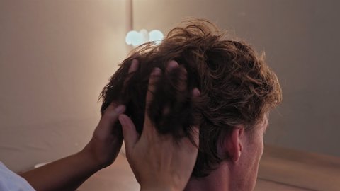 Hairdresser corrects the man's hair. The woman puts the guy's hair after the haircut. Close-up. High quality 4k resolution footage. 